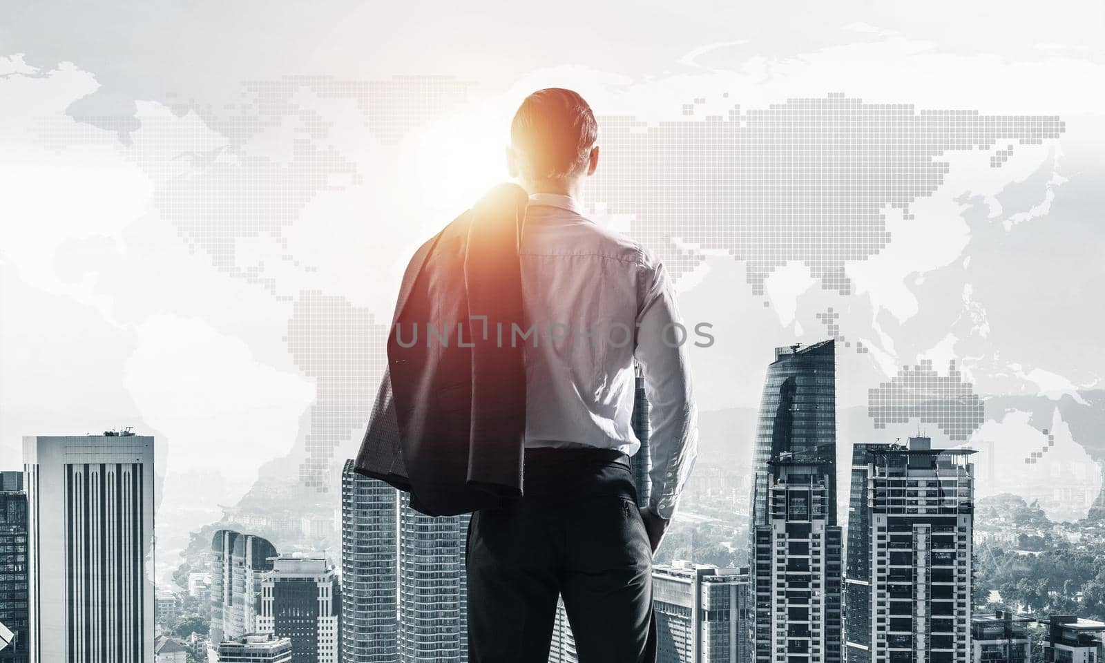 Young elegant businessman with jacket on shoulder looking away