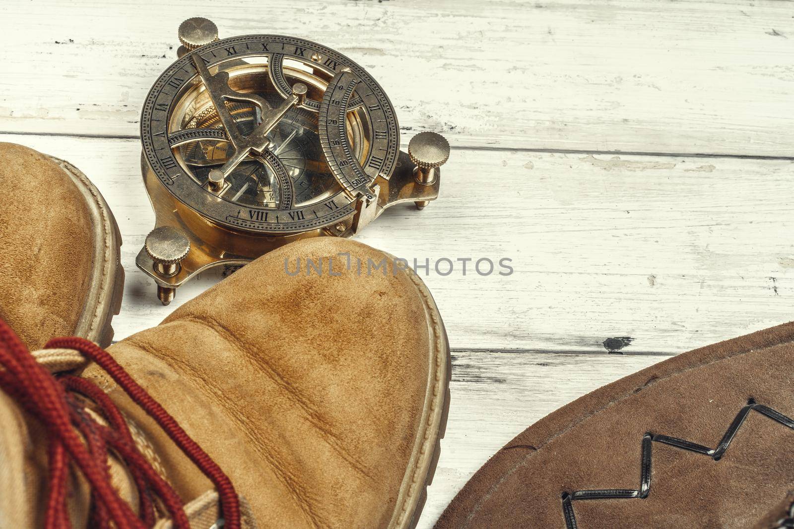 Hiking boots with travel accessories on grunge background. Close up.
