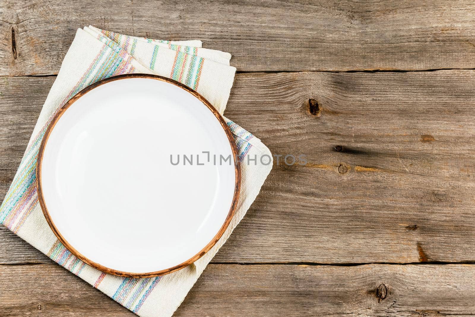 Empty white dish on rustic wooden table by Syvanych