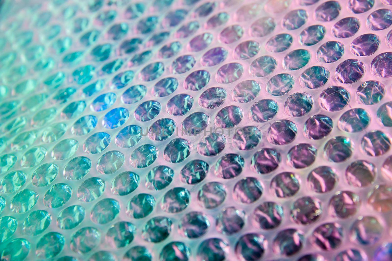 Holographic background in the style of the 80-90s. Real texture of bubble wrap film in bright acid colors. by bashta