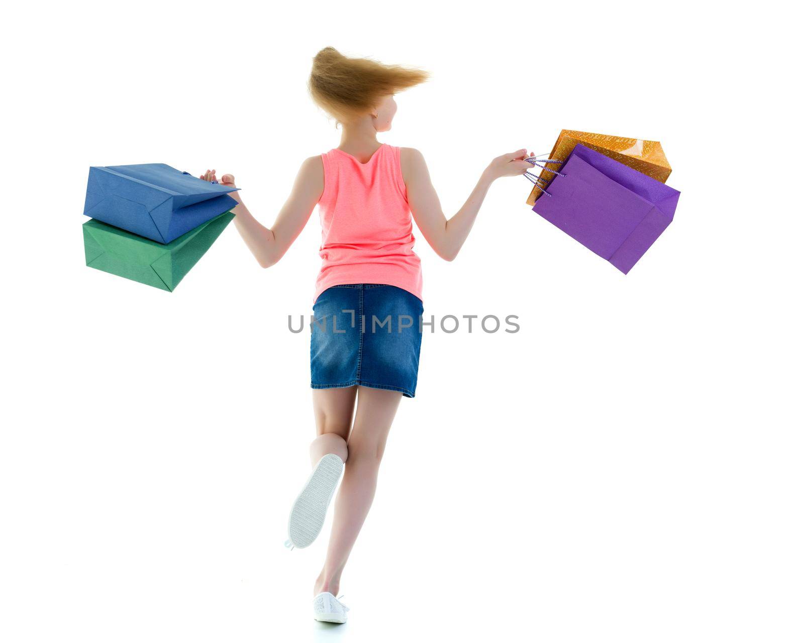 Beautiful teen girl shopping in a store. With large paper bags in hand. The concept of holiday sales, advertising products. Isolated on white background.