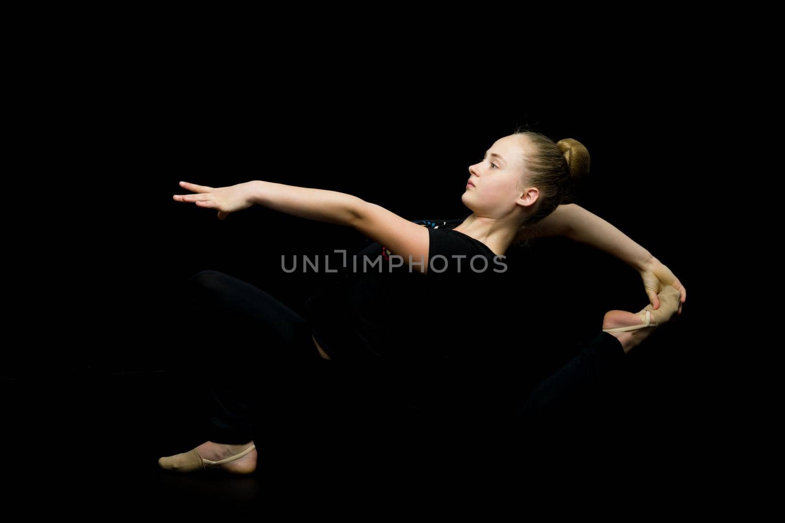 A little girl performs a gymnastic twine. The concept of fitness and sports. Isolated.