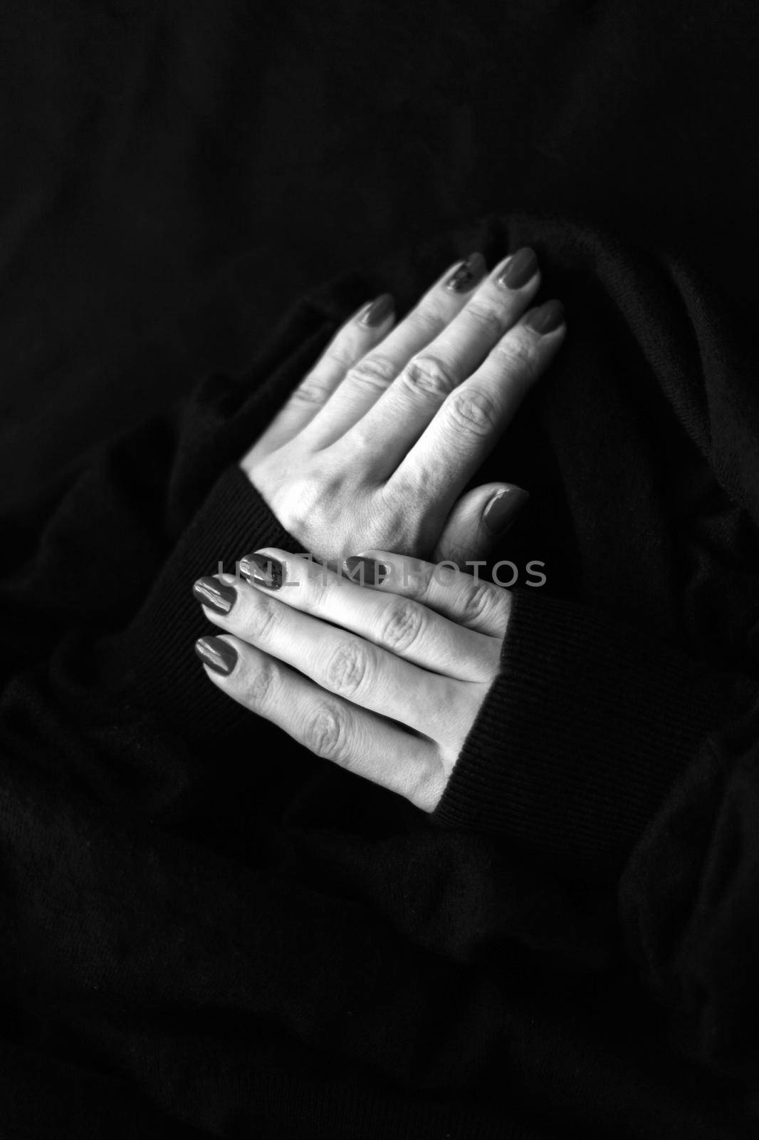 Close up on beautiful female hand with cute manicure on a Black background. black surface by julija
