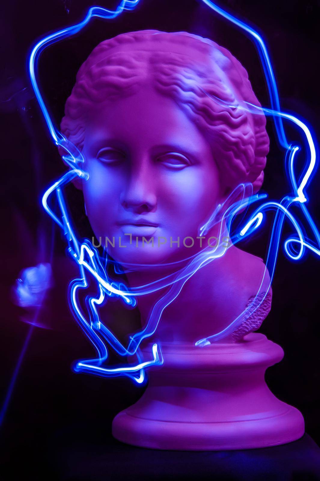 Modern conceptual art colorful poster with ancient statue of bust of Venus. Contemporary art photo. Long exposure. Light brush.