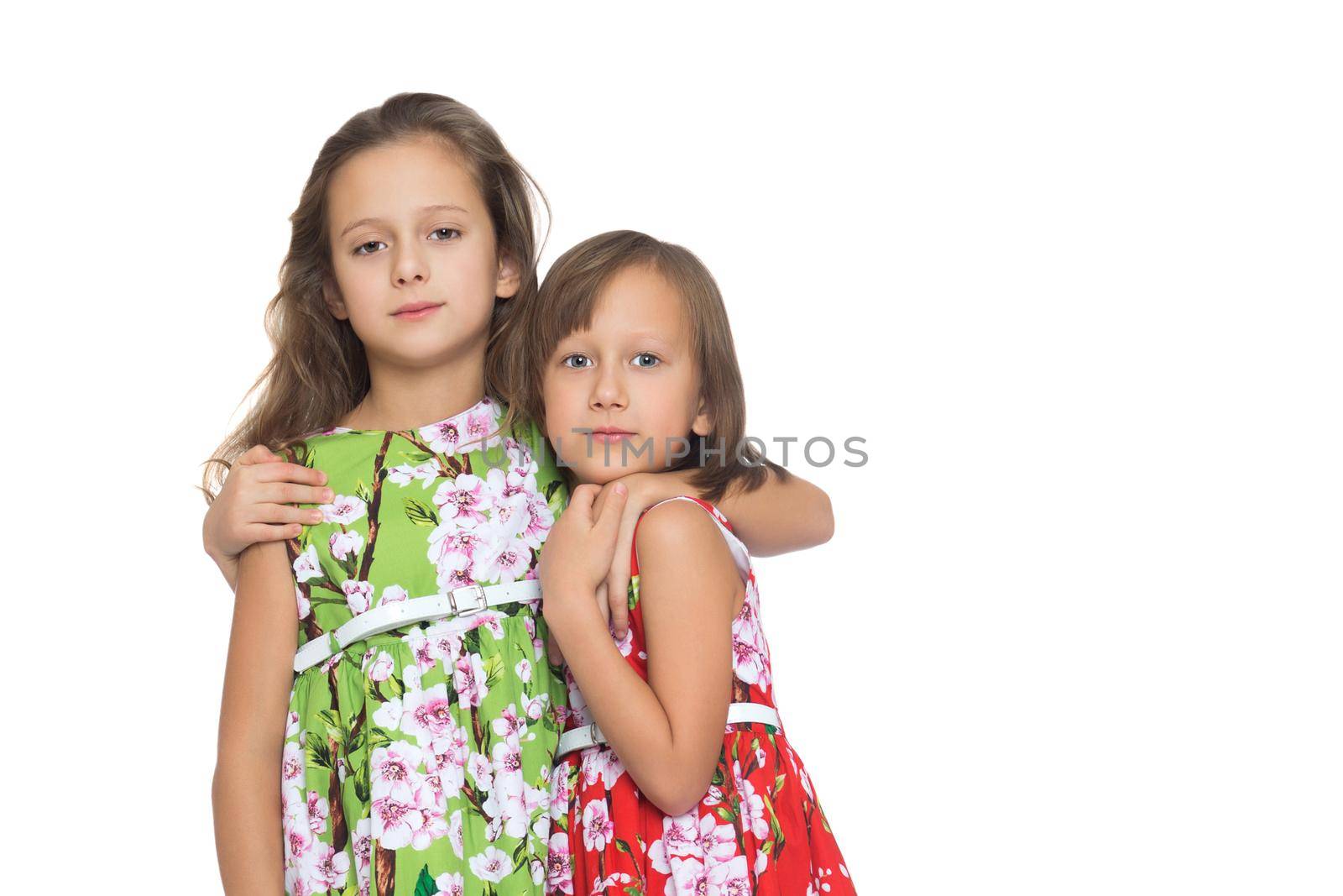 two beautiful girls in elegant summer dresses hugging each other - Isolated on white background