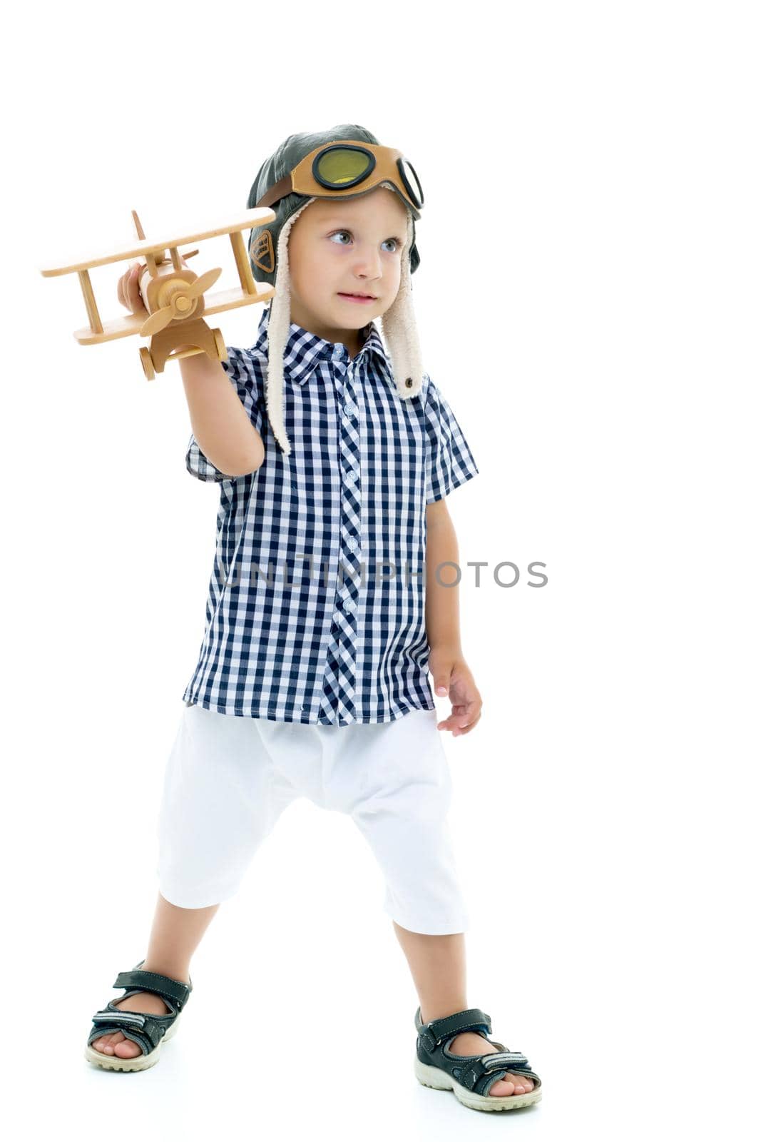 Happy kid boy plays with wooden toy airplane.Isolated on white background.