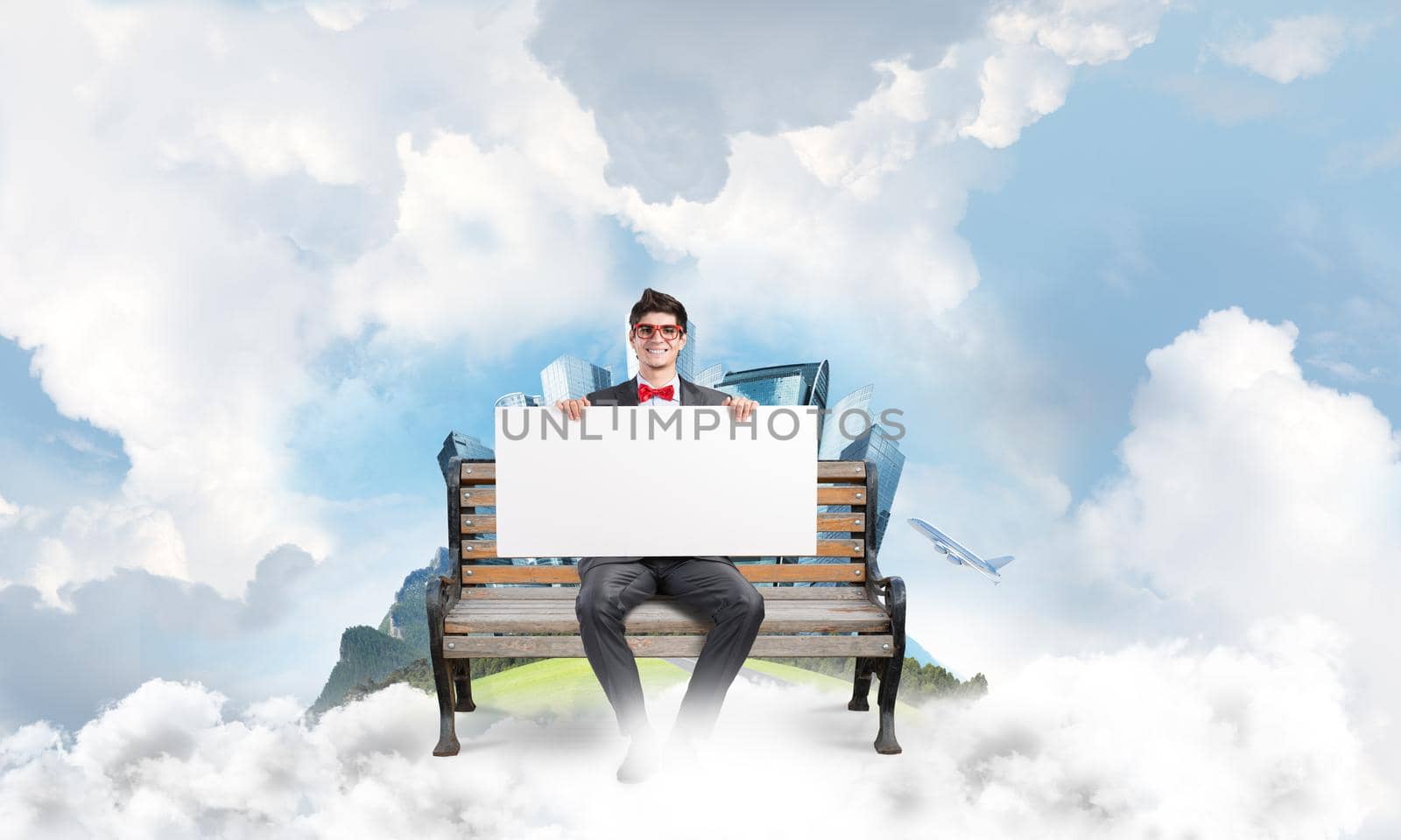Young student sits on a bench and holds an empty banner