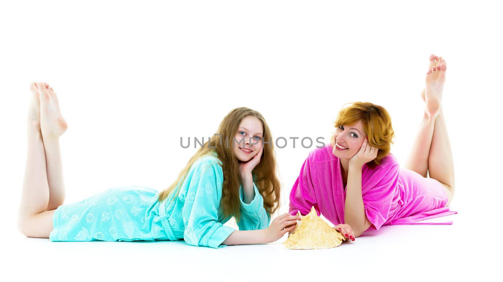 Daughter and mother in bath robes in a photo studio. The concept of relaxation, cosmetics. Isolated on white background