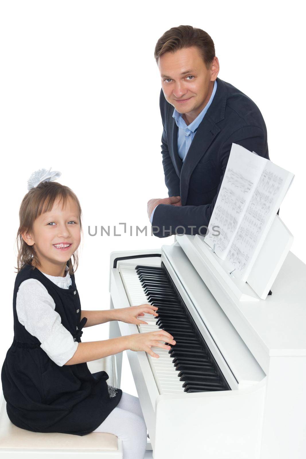 The girl at the music school diligently learn to play piano music , which her music teacher - Isolated on white background