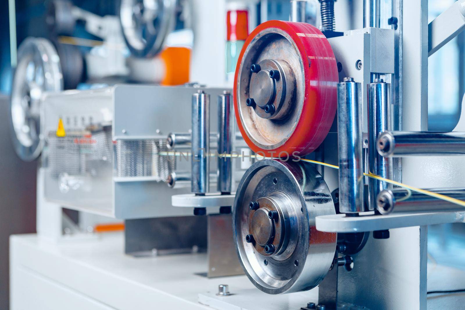 Inside a modern plant producing power electric cables and optical fibers. .Cable manufacturing machine part. Close up.