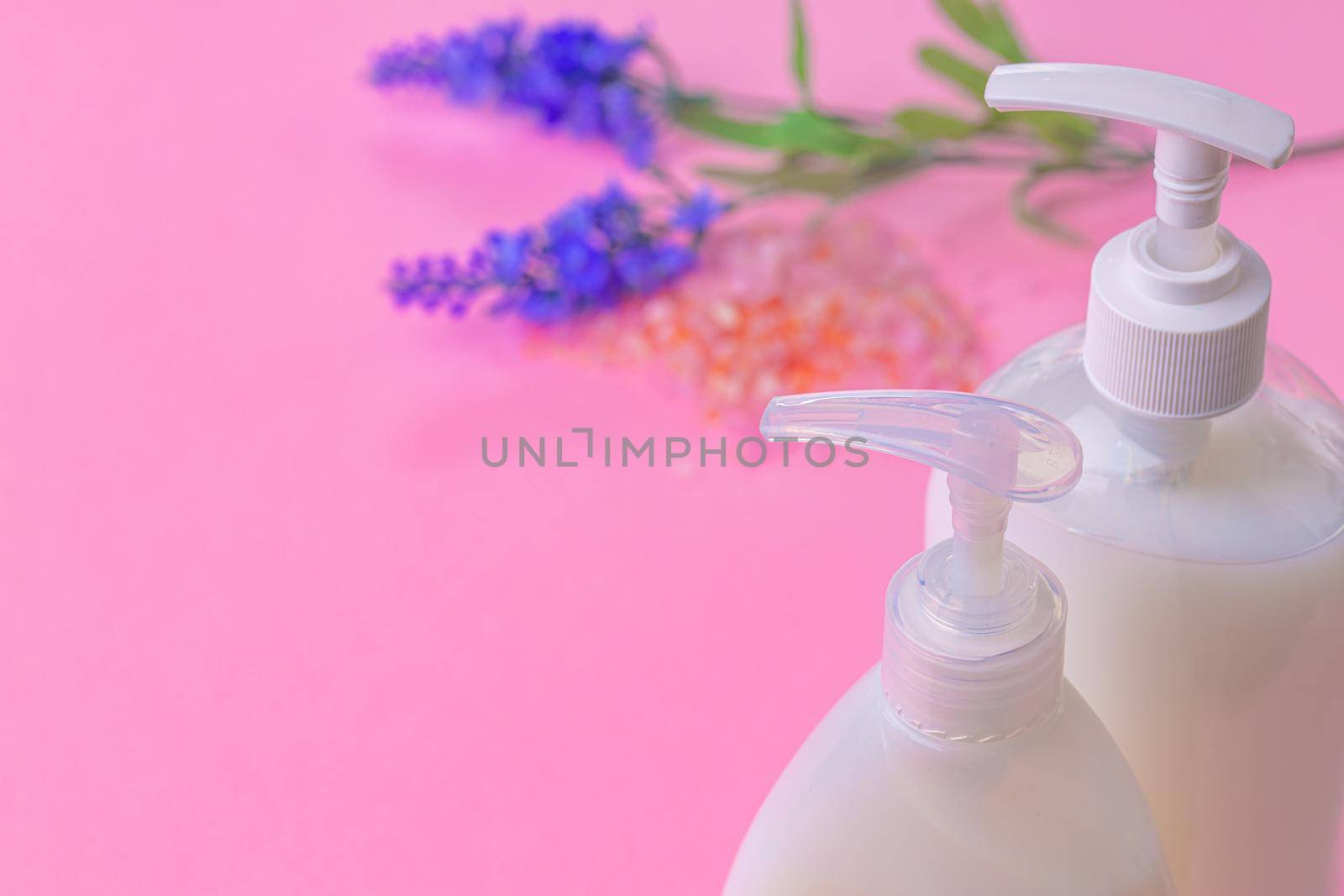 Liquid soap in clear bottle on color background, close up