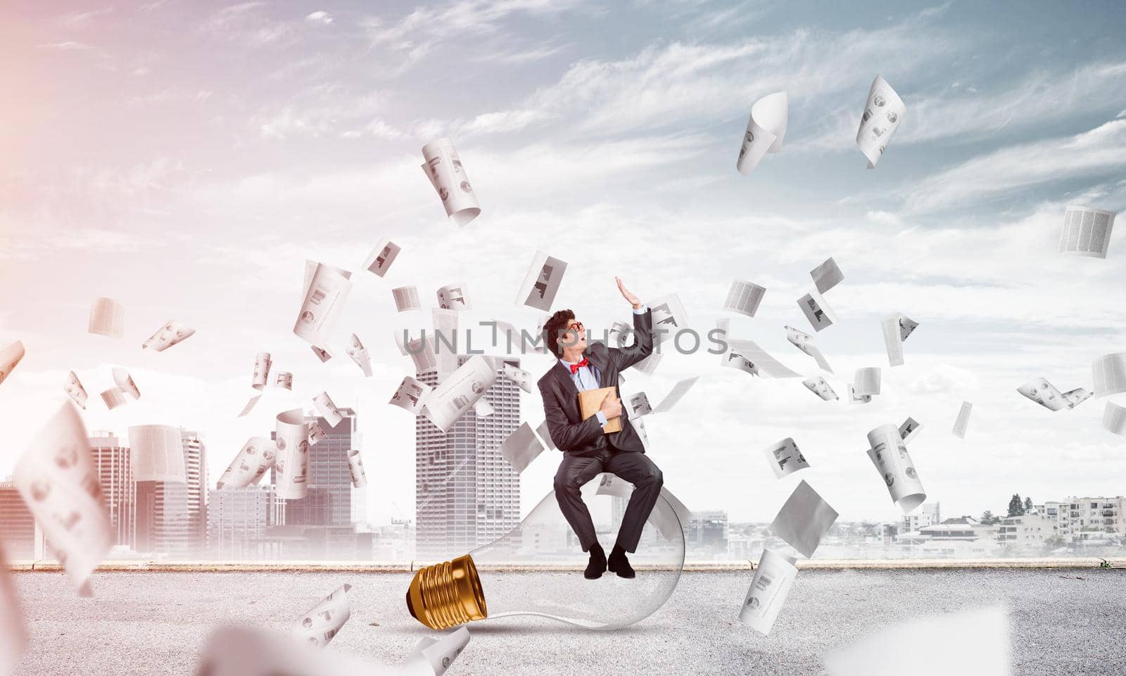 young businessman with a book. flying around papers in chaos