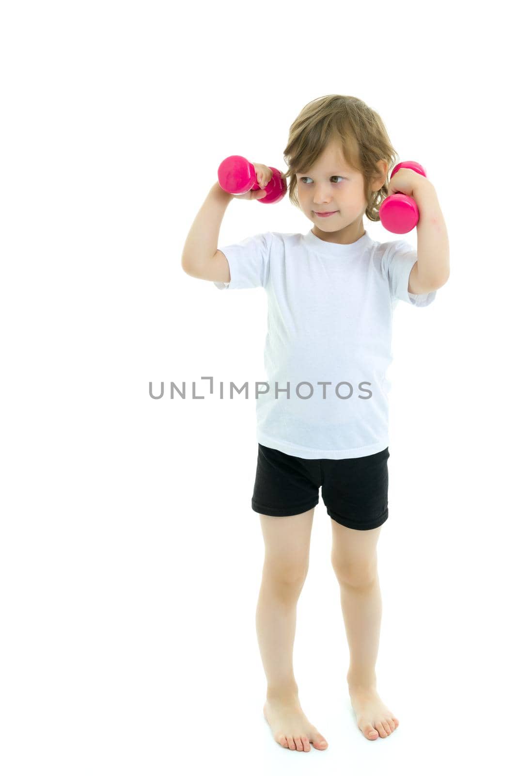 A cute little girl doing exercises with dumbbells. The concept of strength, health and sport. Isolated on white background.