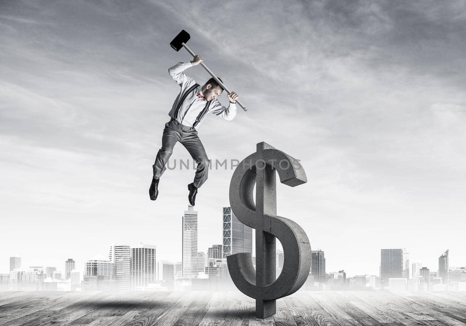 Young furious businessman going to crash with hammer stone dollar symbol