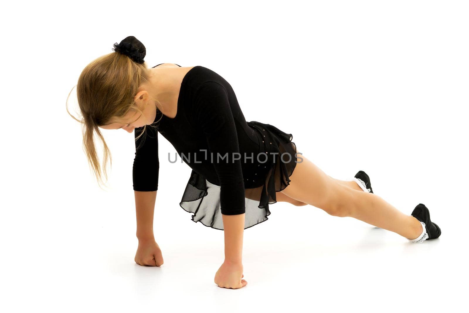 The little gymnast perform an acrobatic element on the floor. by kolesnikov_studio