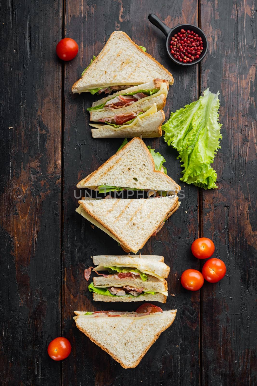 Fresh sandwiches with ingredient, on dark wooden background, top view