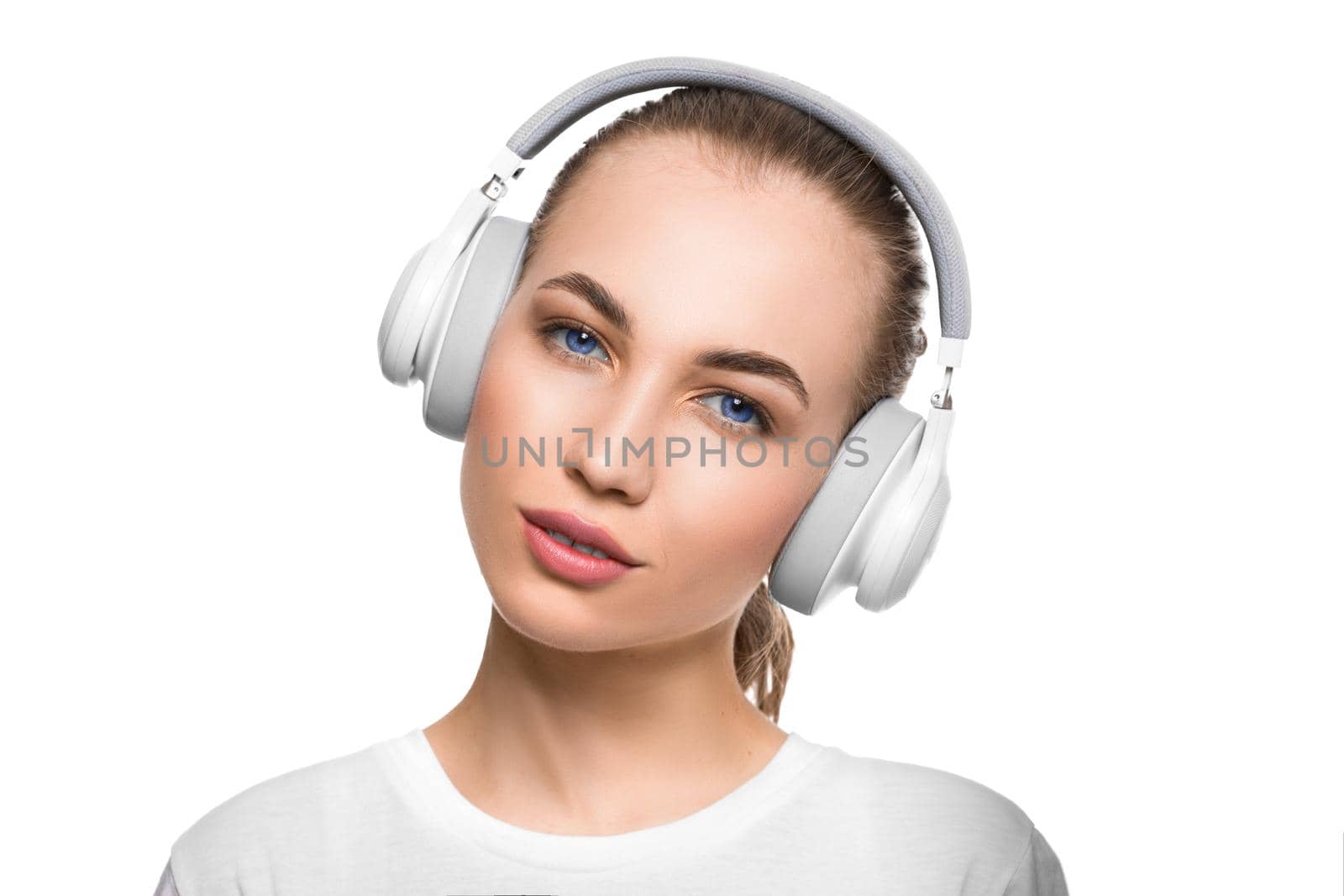 Blue eyed woman in headphones looking at camera. Close up portrait. Isolated on white background.