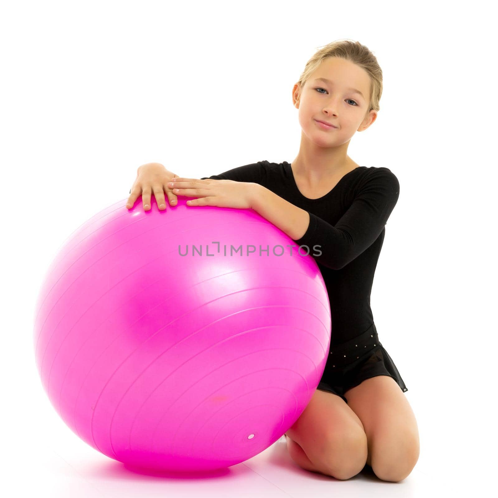 Beautiful little girl doing exercises on a big ball for fitness. The concept of sport and a healthy lifestyle. Isolated on white background.