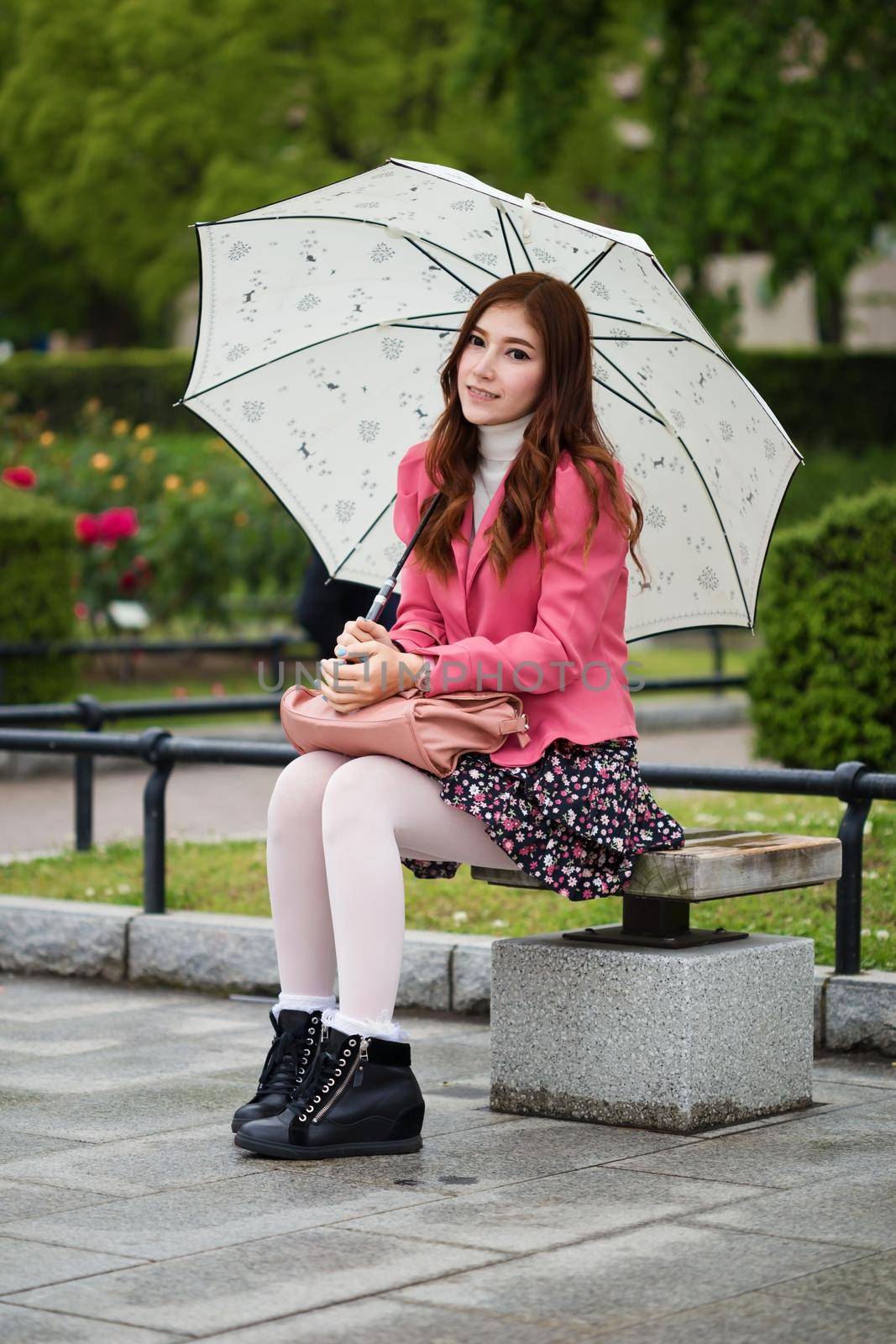 beautiful woman happy with umbrella in the garden