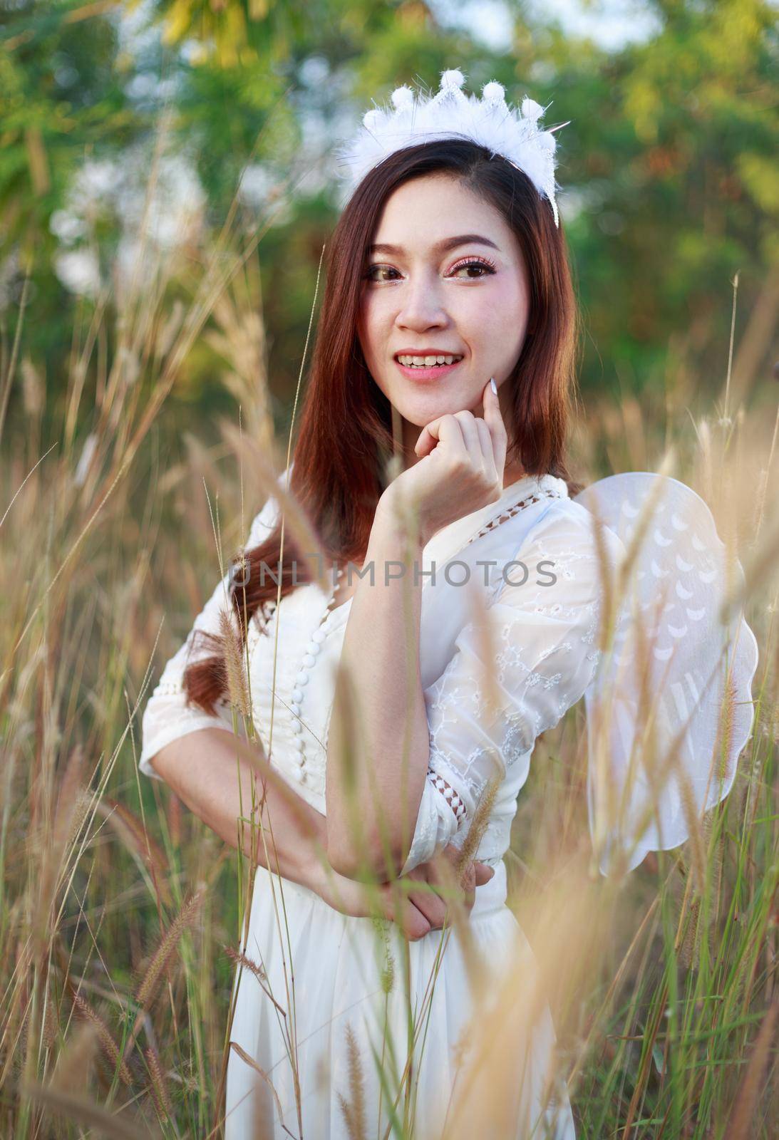 beautiful angel woman in a grass field 