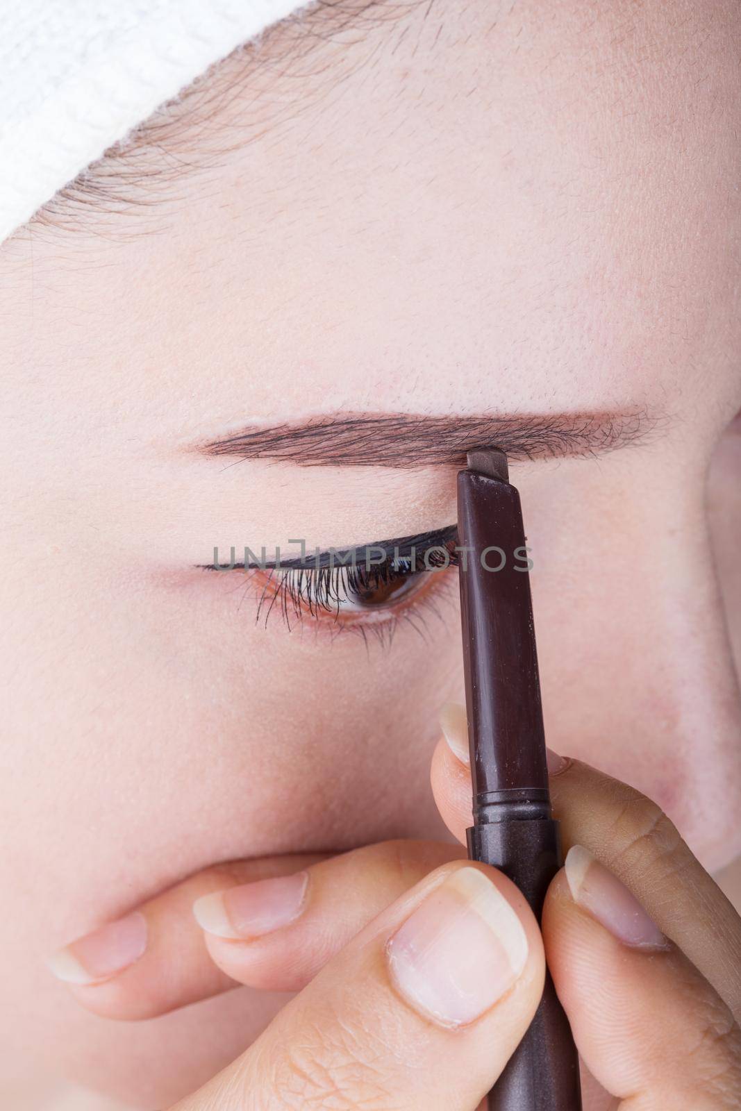 close-up woman using pencil makeup eyebrow 