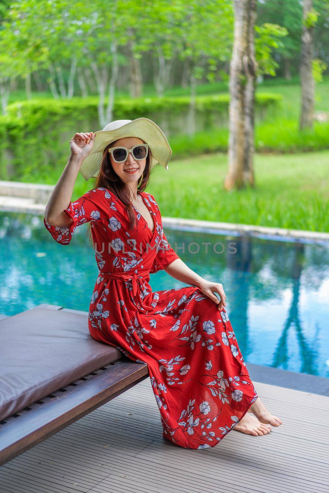 woman sitting on chair near swimming pool by geargodz