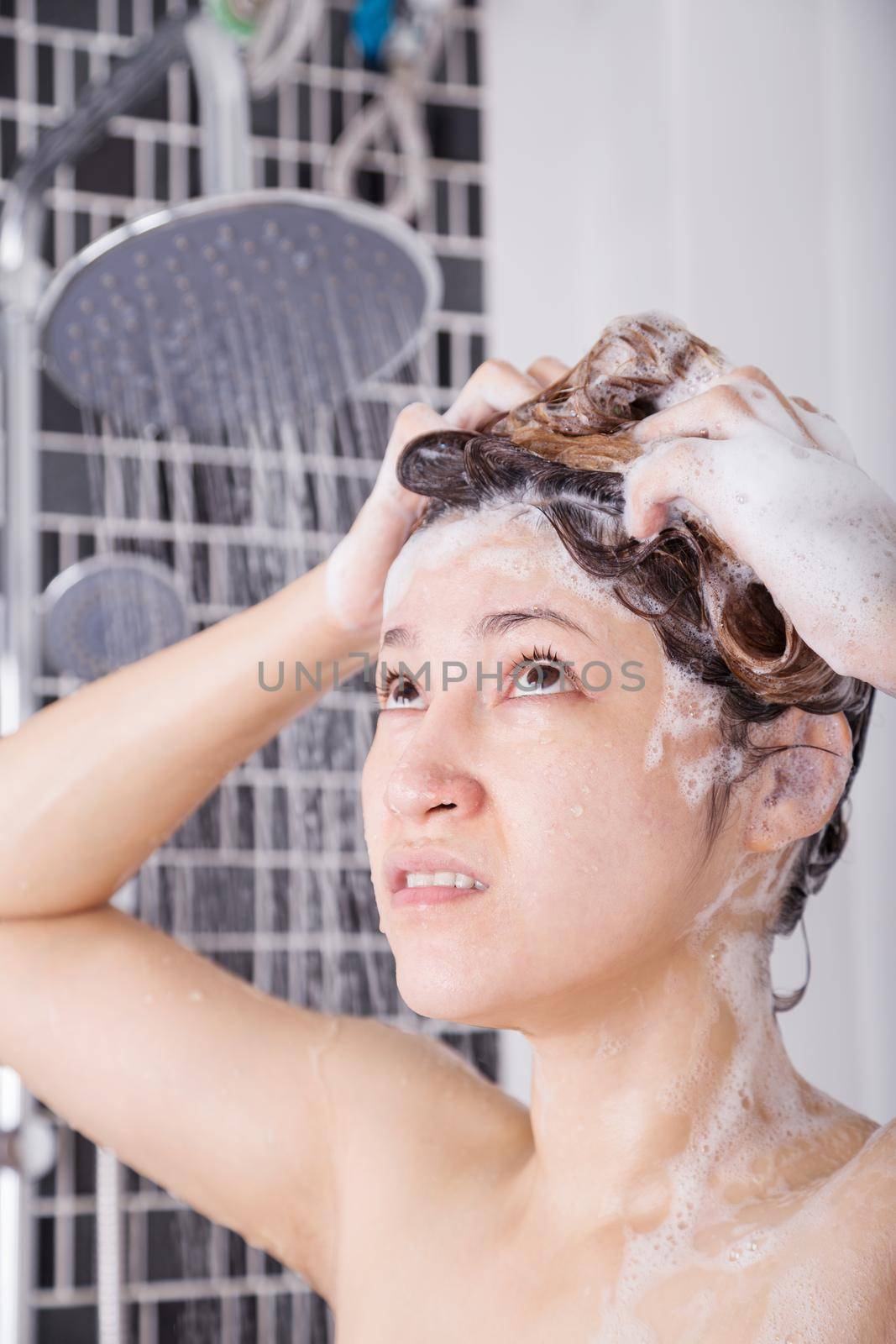 unhappy woman washing head with shampoo and the shower