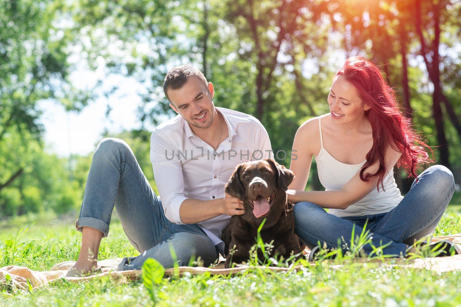 A couple and their dog in the park. Spending time with friends