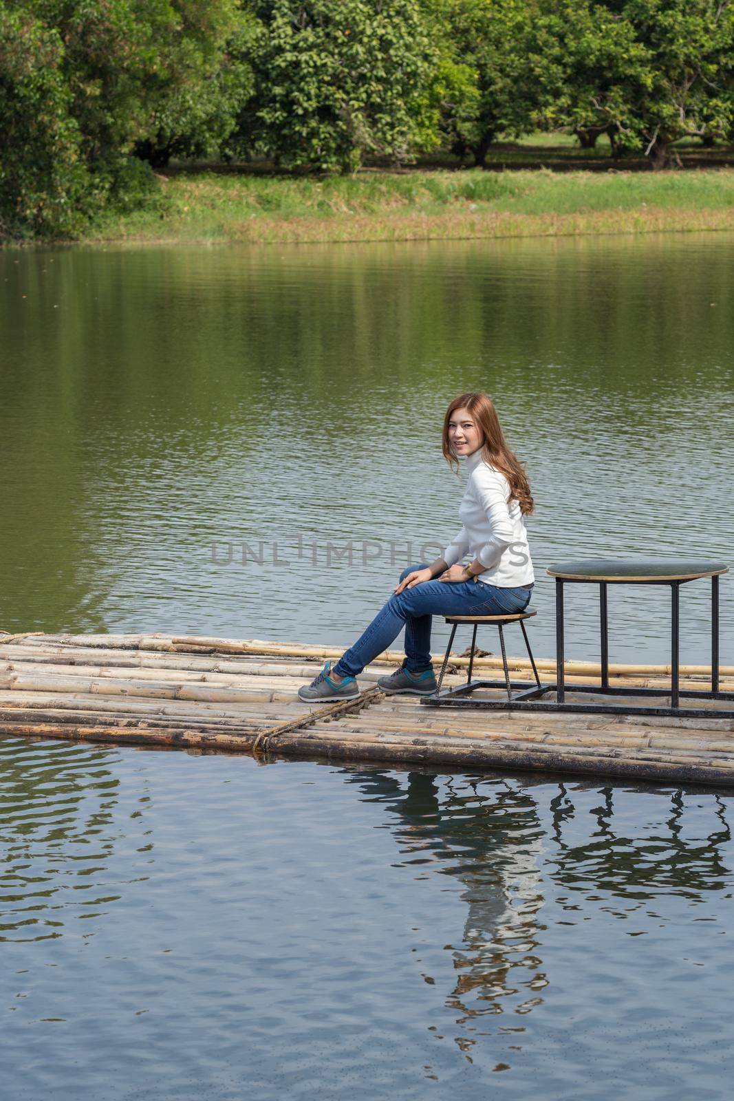 Woman sitting on a bamboo raft in the river