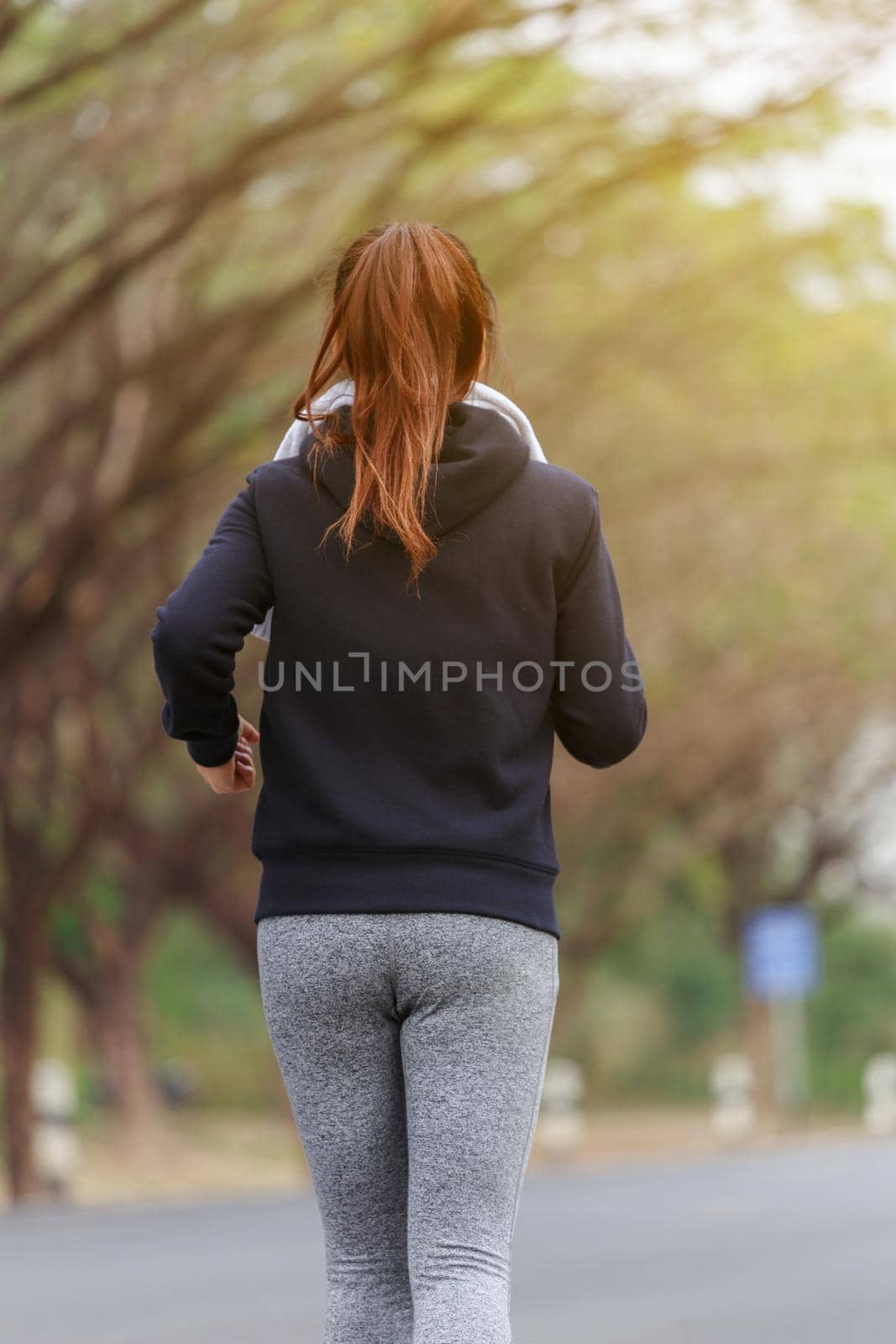 young fitness woman running in park by geargodz