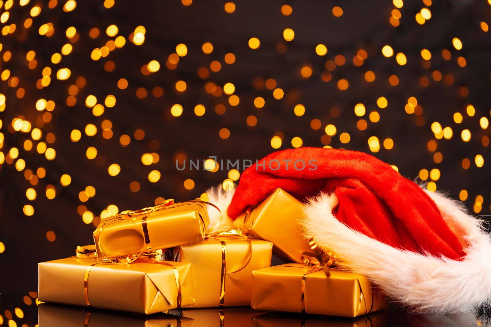 Wrapped Christmas gifts on golden lights bokeh background close up