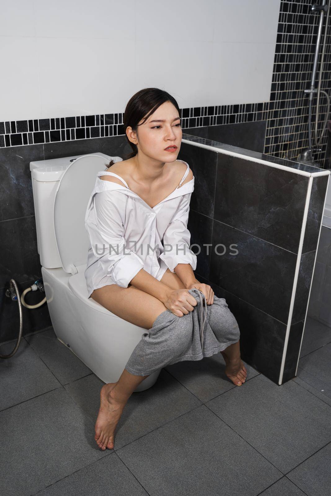 young woman sitting on a toilet