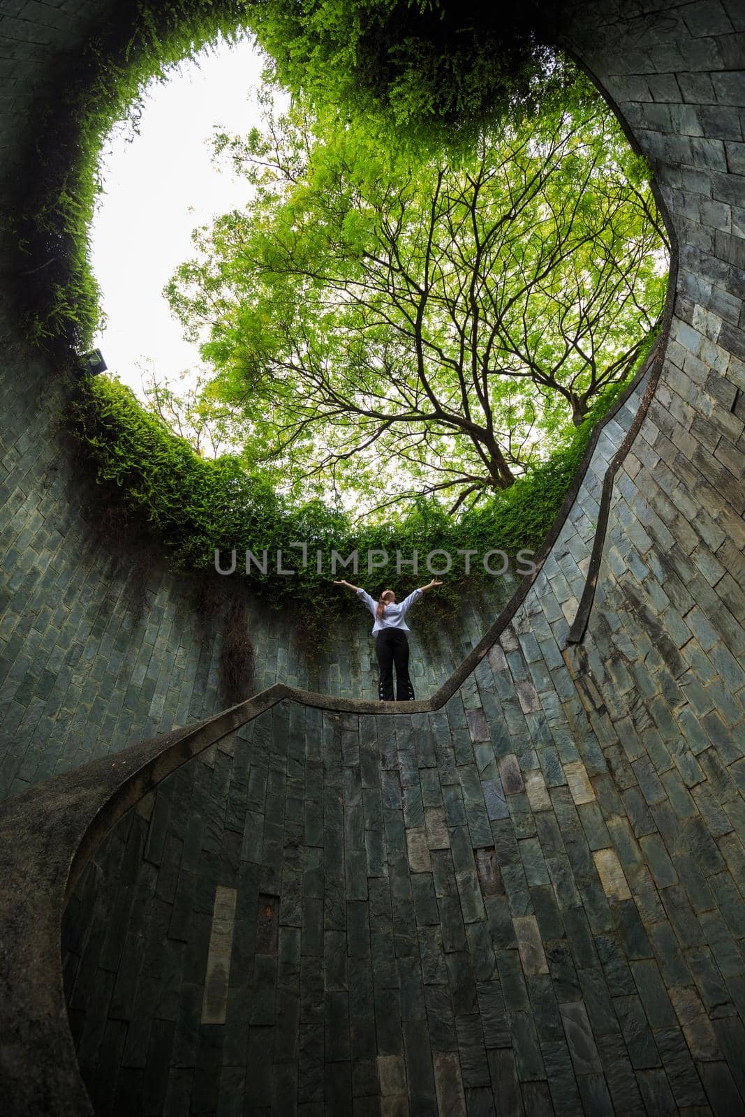 woman hands up in underground crossing at Fort Canning Park, Singapore by geargodz