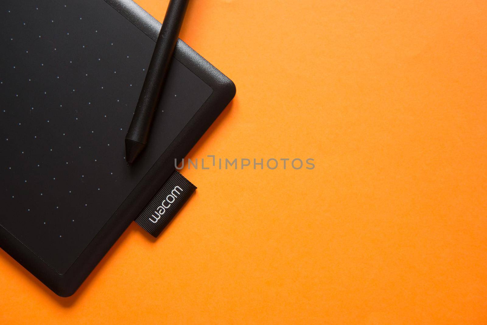 Tver, Russia - February 3, 2020; Top view of Wacom graphic tablet on orange background. Space for text. Selective focus.