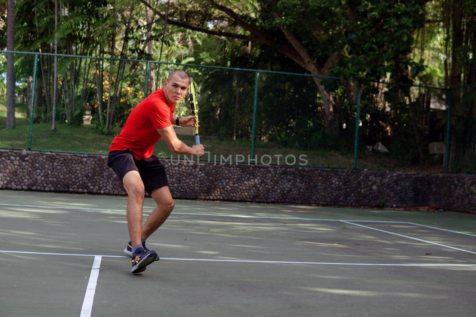 man in red sportwear playing tennis by Alexzhilkin