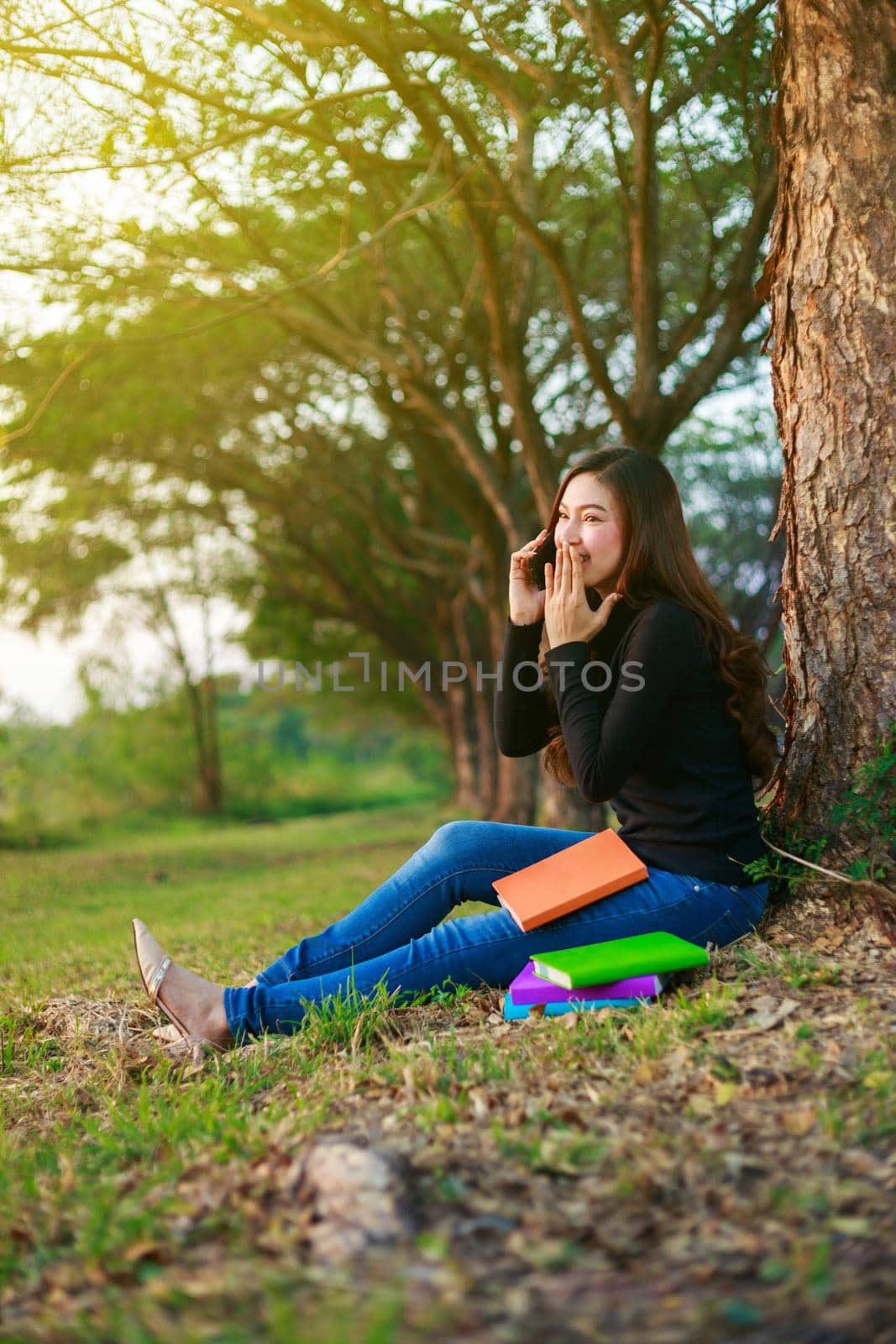 cheerful woman talking on mobile phone in park by geargodz