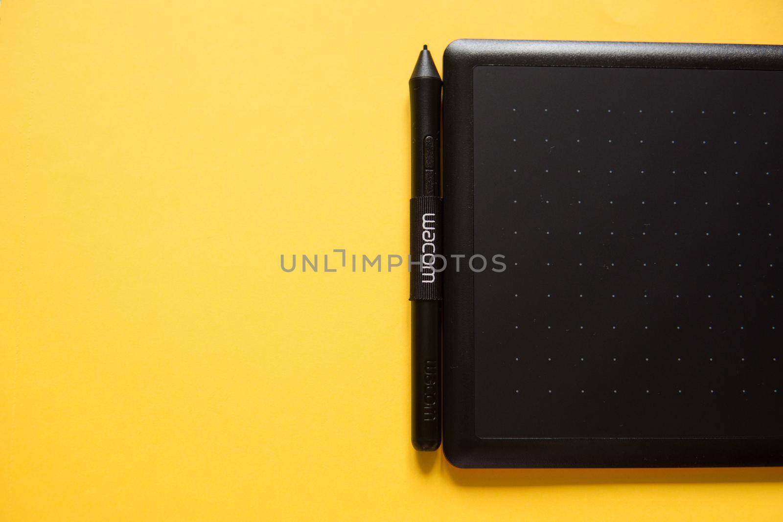 Tver, Russia - February 3, 2020; Top view of Wacom graphic tablet on yellow background. Space for text. Selective focus. by Annu1tochka