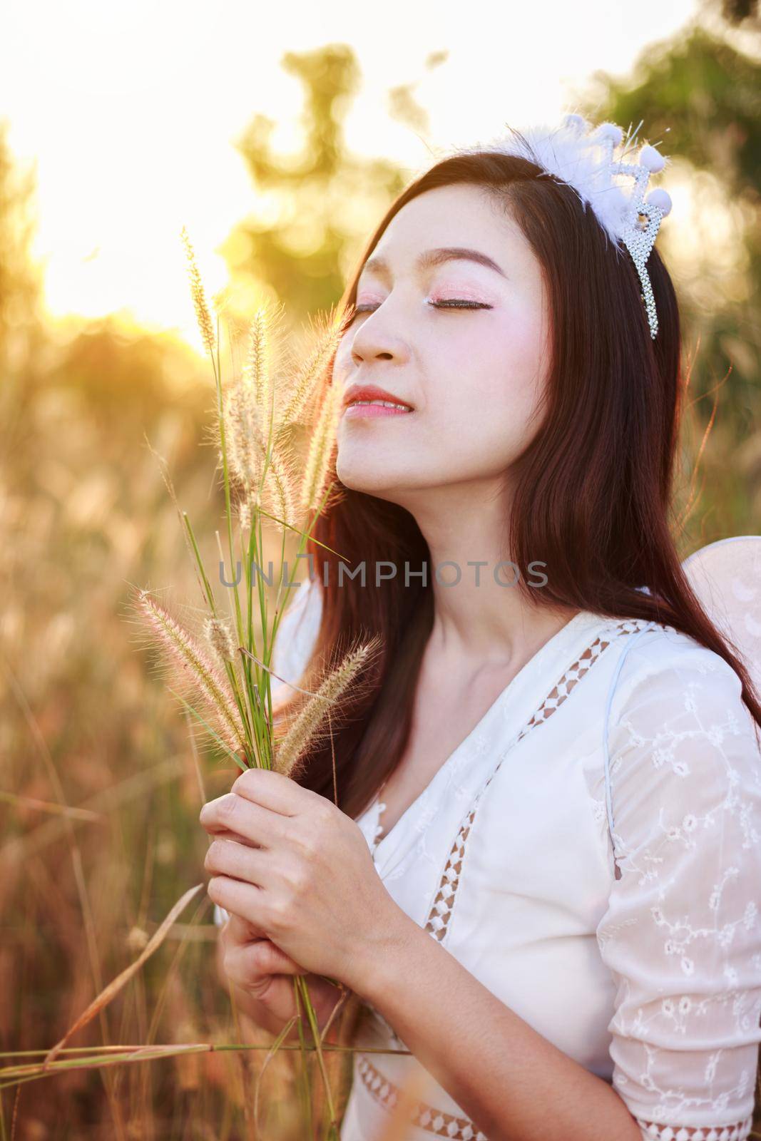 angel woman in a grass field with sunlight by geargodz