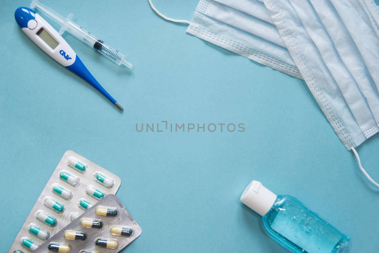 Virus prevention and treatment: wearing masks, hand disinfection, taking antiviral drugs and vitamins. First aid kit with medicines on a blue background.