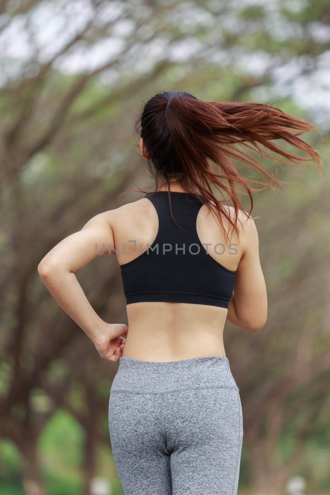 young fitness woman running in park by geargodz