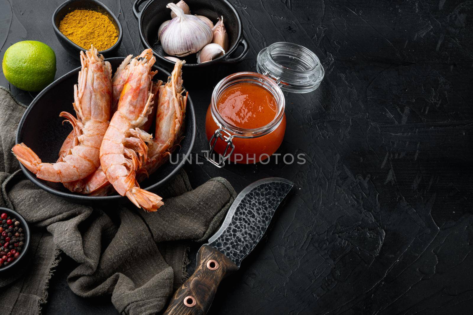 Mango chutney Large raw shell on raw king prawns ingredients set in bowl, on black background , with copyspace and space for text