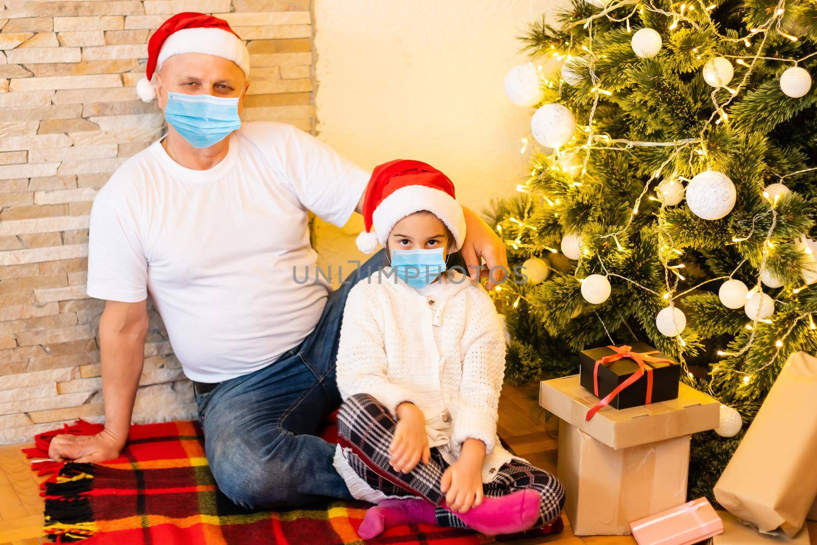 People with gifts wearing facemasks during coronavirus and flu outbreak on Christmas. Virus and illness protection, home quarantine. COVID-2019.