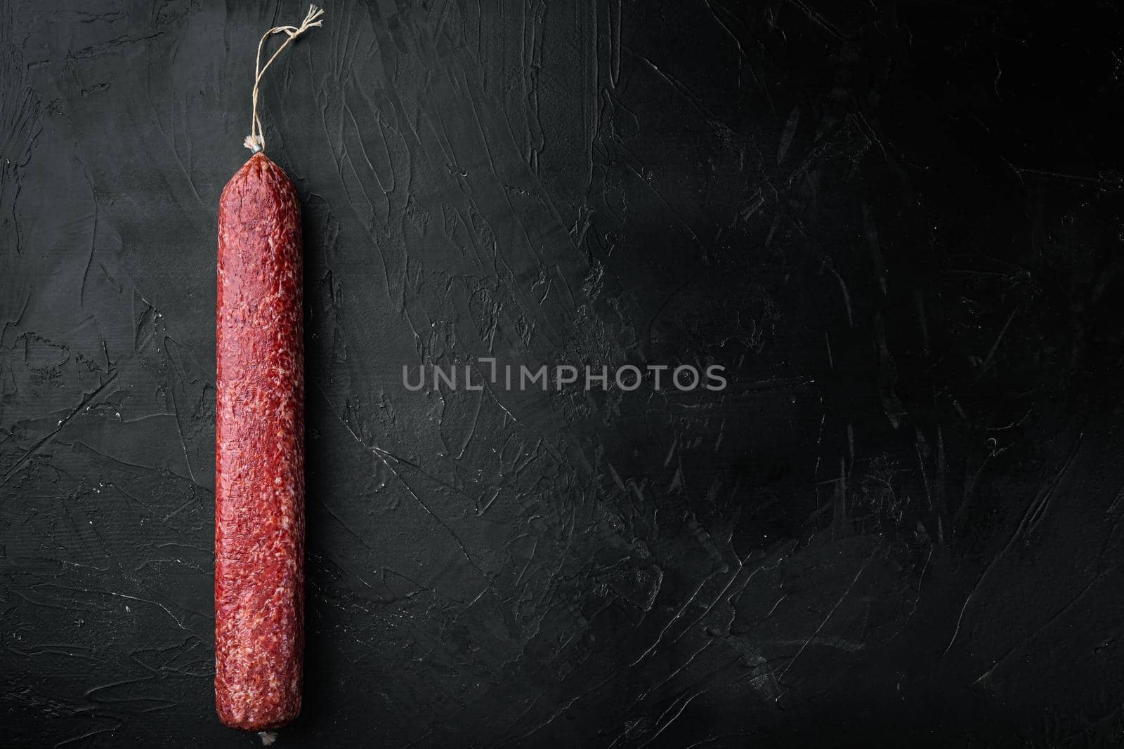 Sausage paperoni Salami with paprika set, on black dark stone background, top view flat lay, with copy space for text