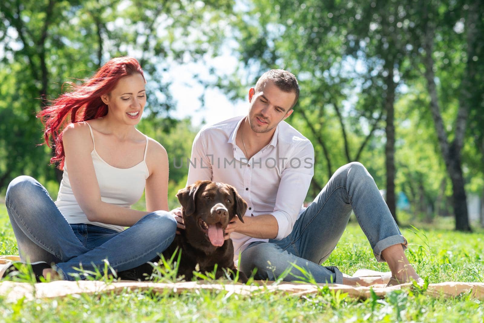 A couple and their dog in the park. Spending time with friends