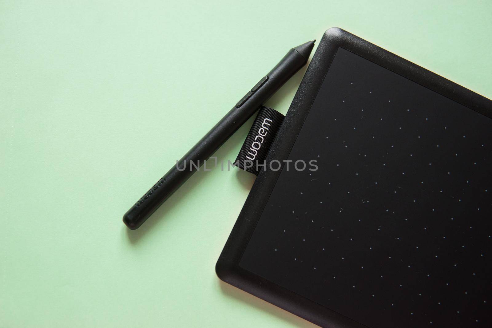 Tver, Russia - February 3, 2020 Top view of Wacom graphic tablet on pastel green background. Space for text. Selective focus.