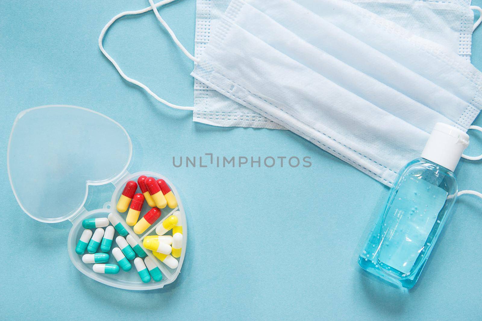Respiratory mask and medicine in capsules on blue background.Virus prevention and treatment.