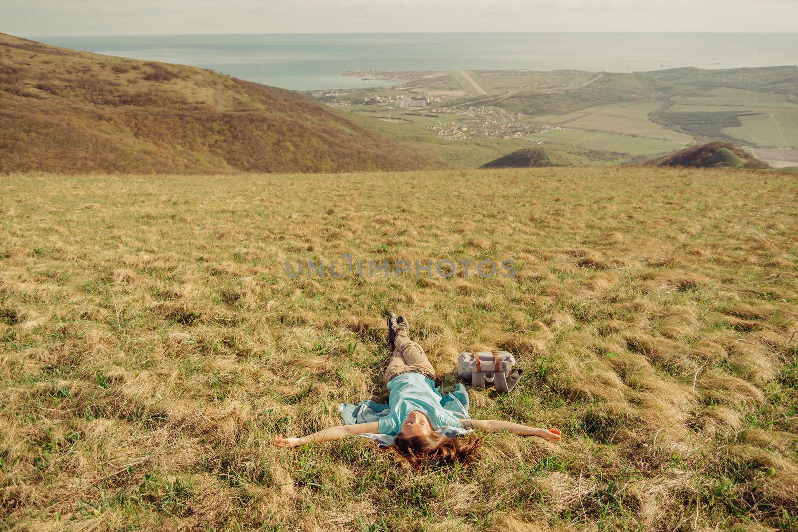 Happy hiker woman lying on meadow by alexAleksei