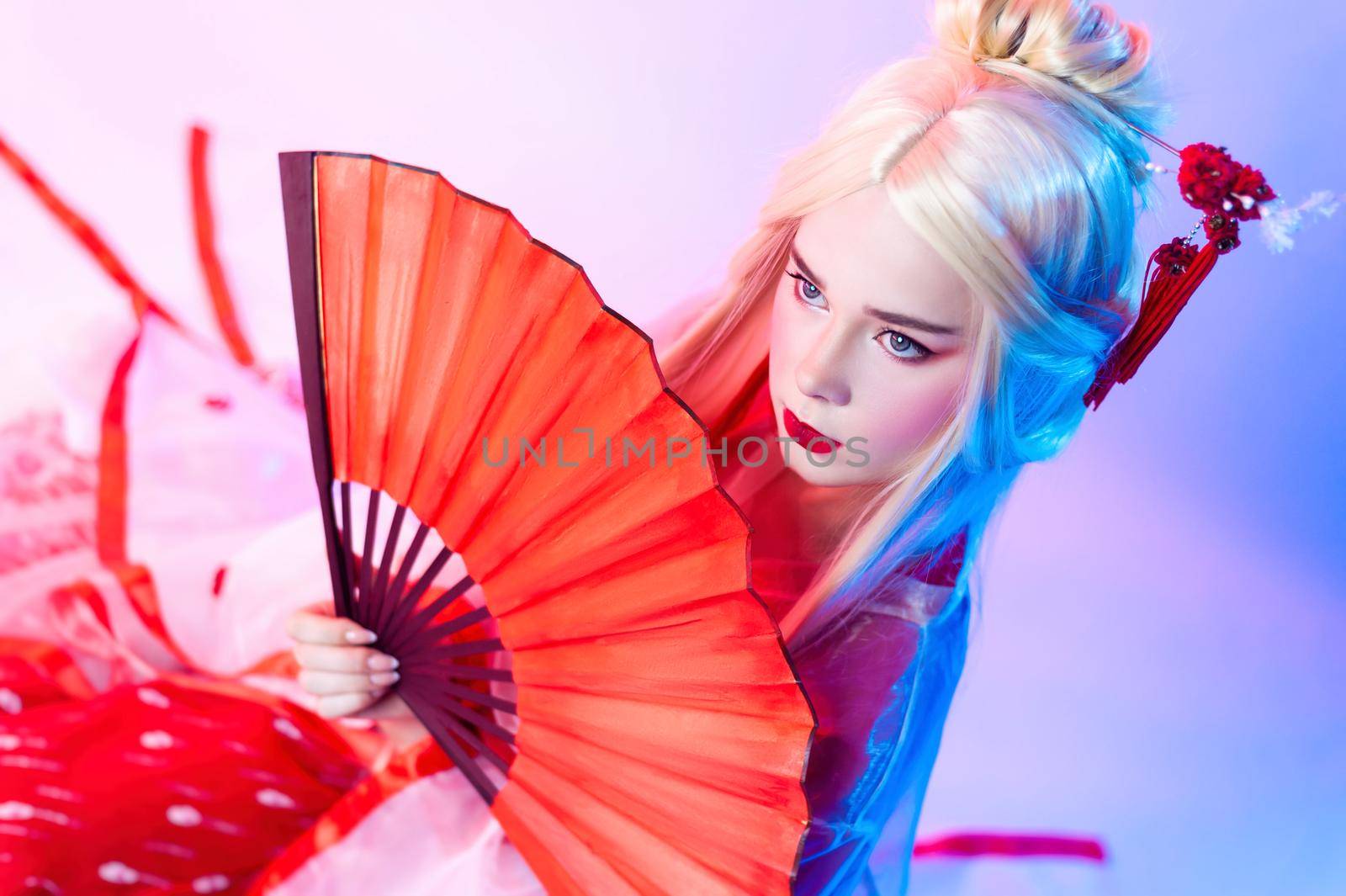 the woman in a geisha costume with fans sits on a white background