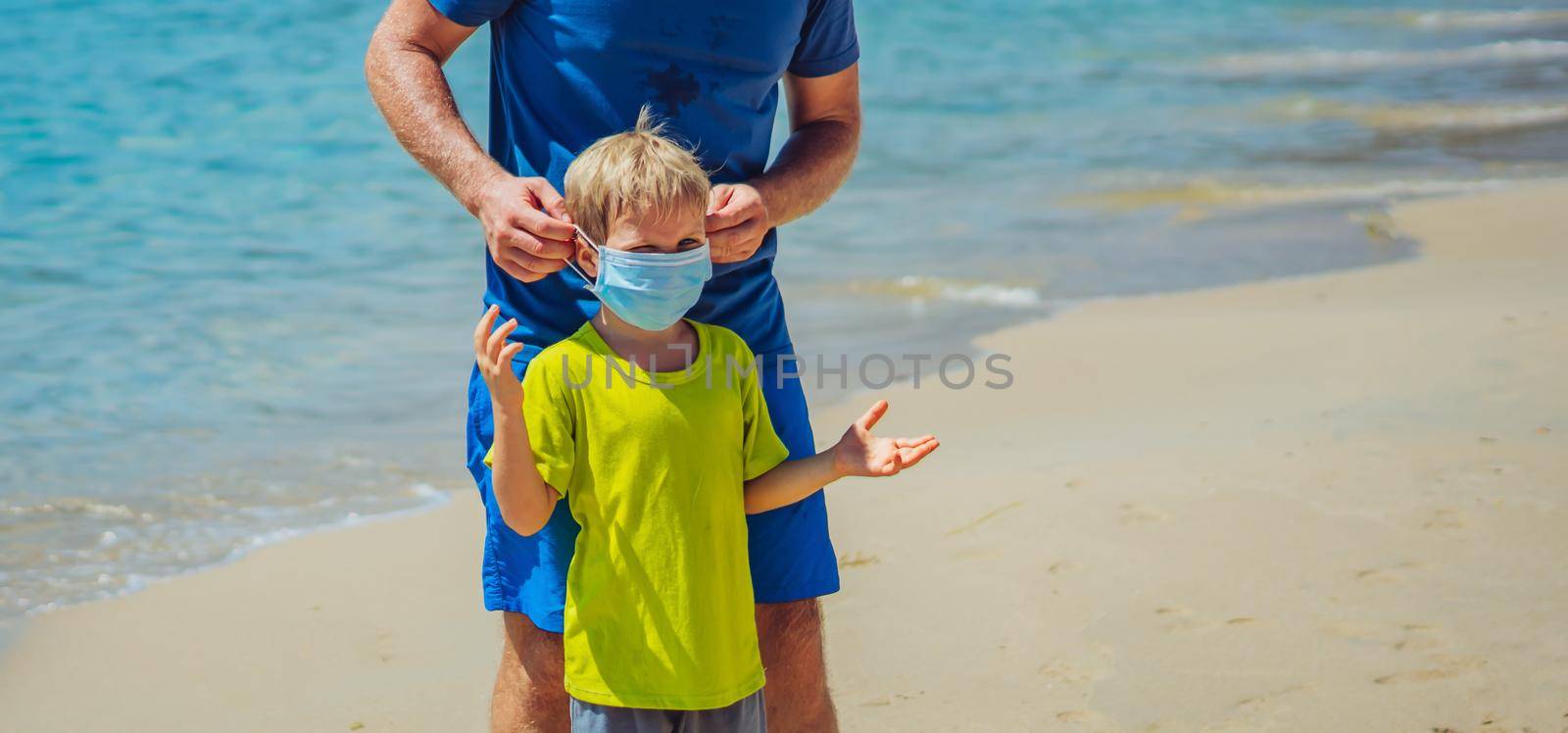 Normal reality COVID pandemic. Father ask boy put on mask protect coronavirus, son refuses does not want to constantly wear it everywhere, get tired of mask, walk nature sea beach forest park sun day.