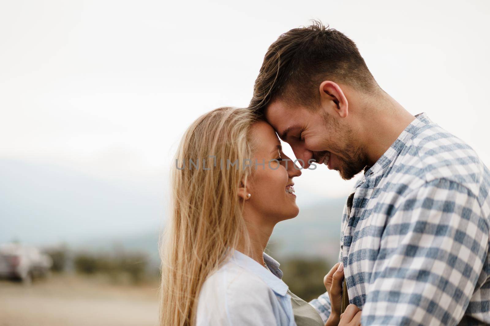 Happy loving couple hiking and hugging in mountains, close up